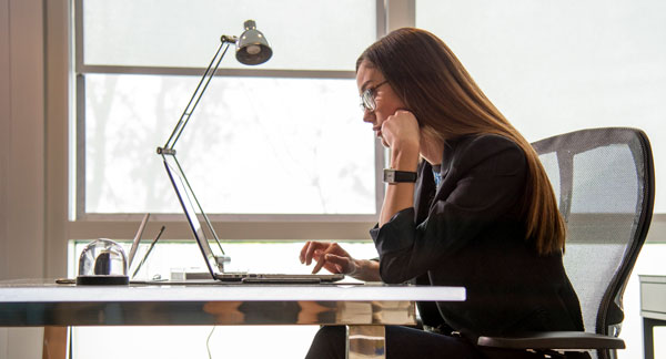 Employee working at her desk. Employee working at her desk.