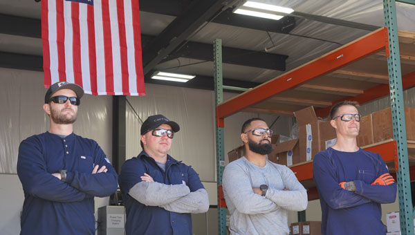 Four NextEra Energy employees, who served in the military, in front of the American flag.
