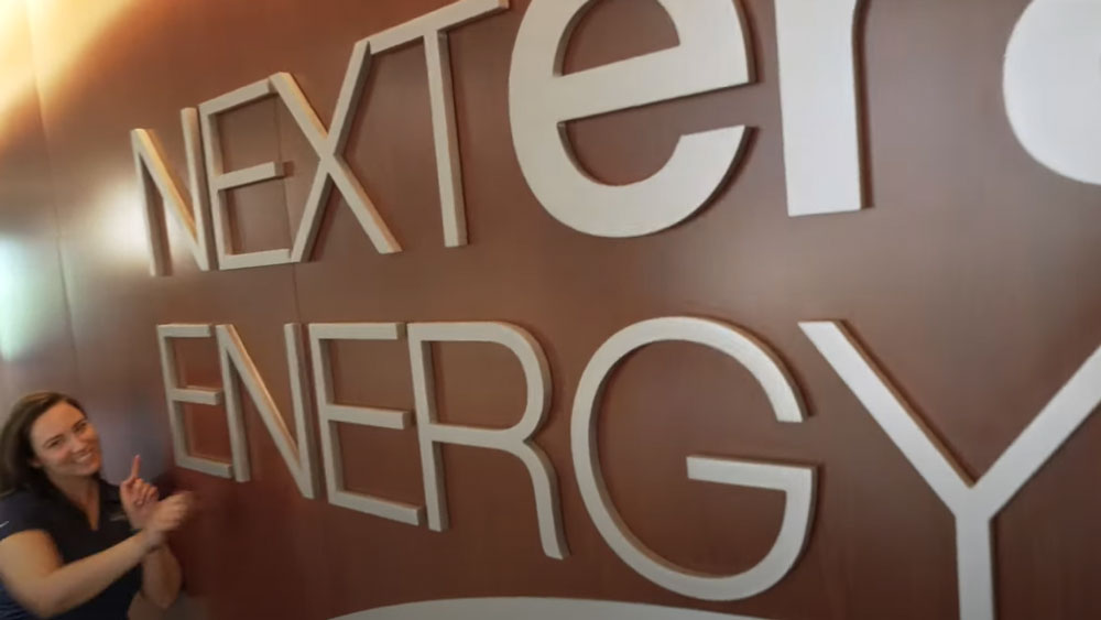 NextEra Employee by a NextEra Energy sign