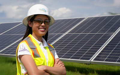 Allison Bernard posing in front of solar panels