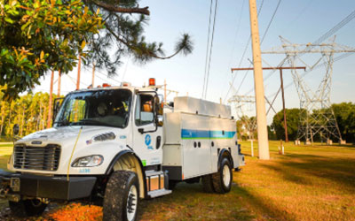 FPL trucks by a transmission pole