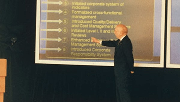 Man presenting quality improvement ideas onstage