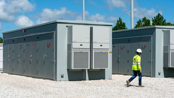 NextEra employee walking by a battery storage facility unit