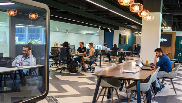 People working in an open concept office People working in an open concept office
